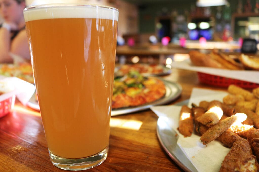 best happy hour in reno with beer and assorted pizza wings and appetizers on table